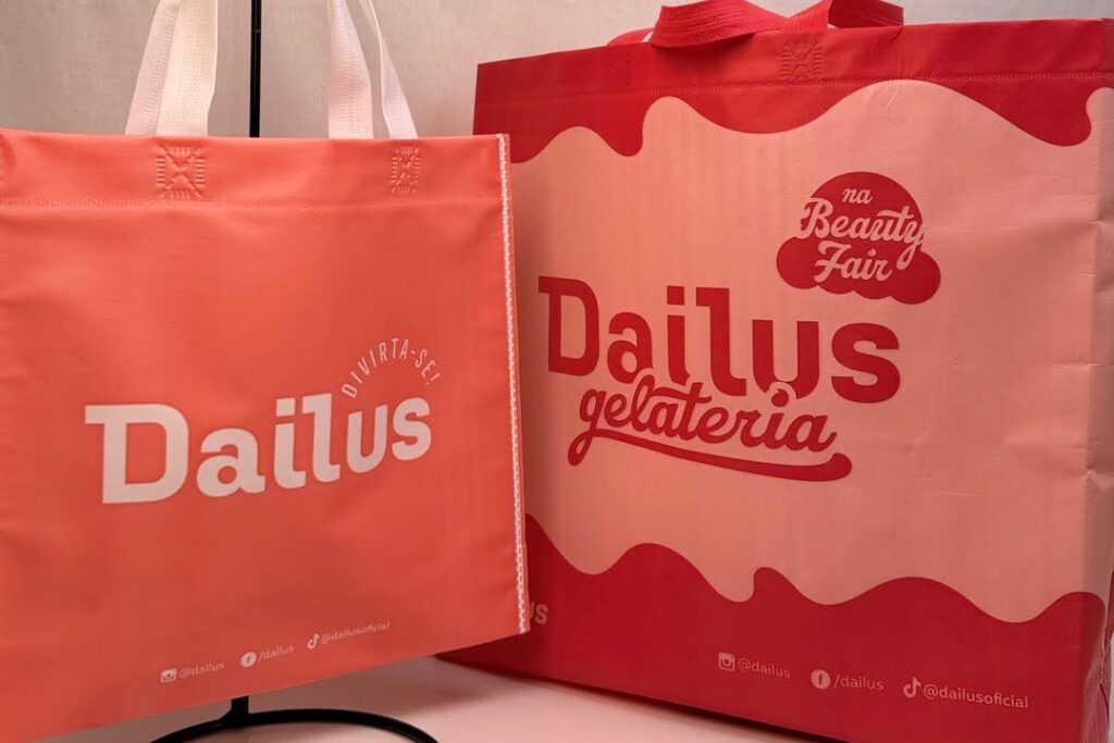 Sacolas recicl&aacute;veis personalizadas produzidas pela Amaz&ocirc;nia Bags para a marca Dailus, usadas em a&ccedil;&otilde;es de varejo e eventos como alternativa sustent&aacute;vel &agrave;s sacolas pl&aacute;sticas.