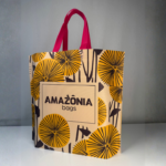 Sacola sustentável personalizada da Amazônia Bags com estampa floral e alças rosas, representando a embalagem como parte da experiência do cliente e do branding da marca.