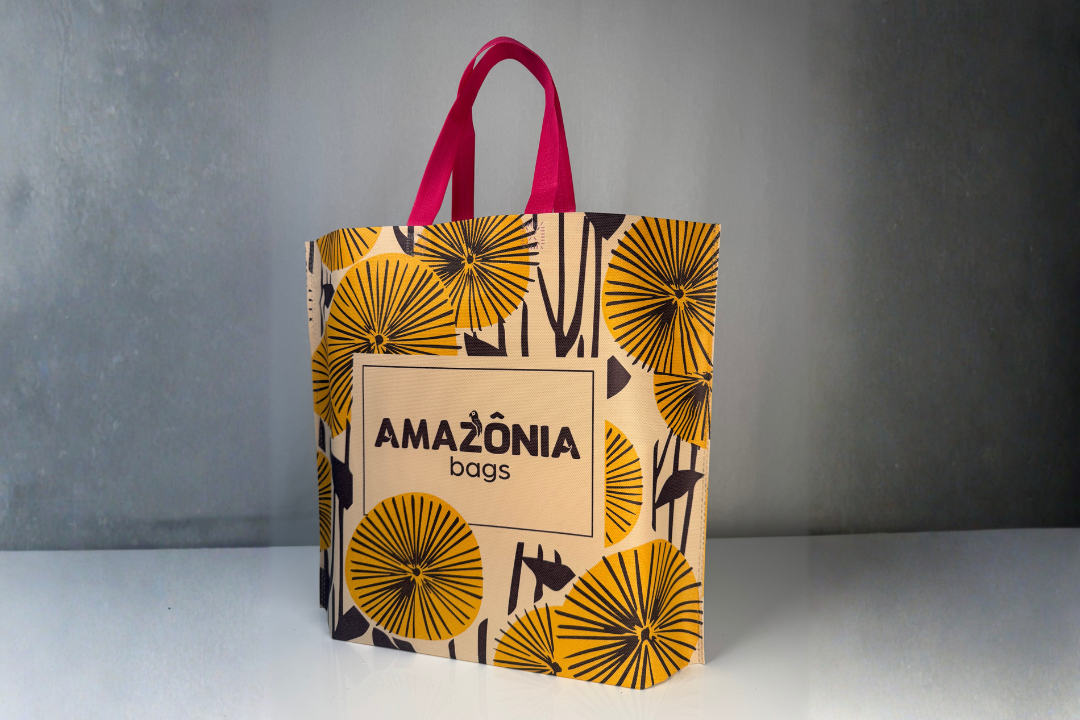 Sacola sustentável personalizada da Amazônia Bags com estampa floral e alças rosas, representando a embalagem como parte da experiência do cliente e do branding da marca.