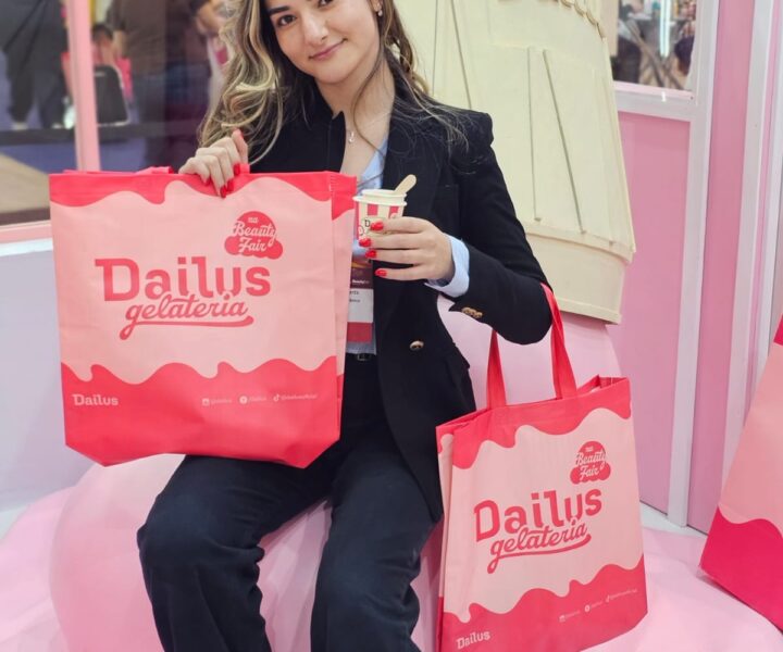 Mulher em um evento carregando sacolas personalizadas da marca