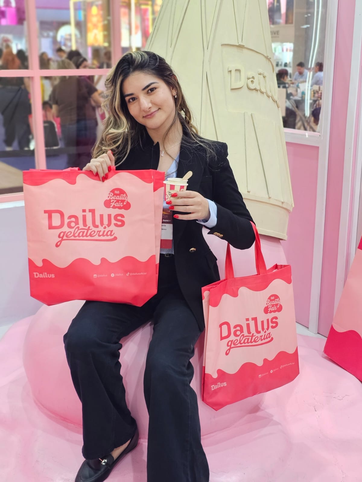 Mulher em um evento carregando sacolas personalizadas da marca