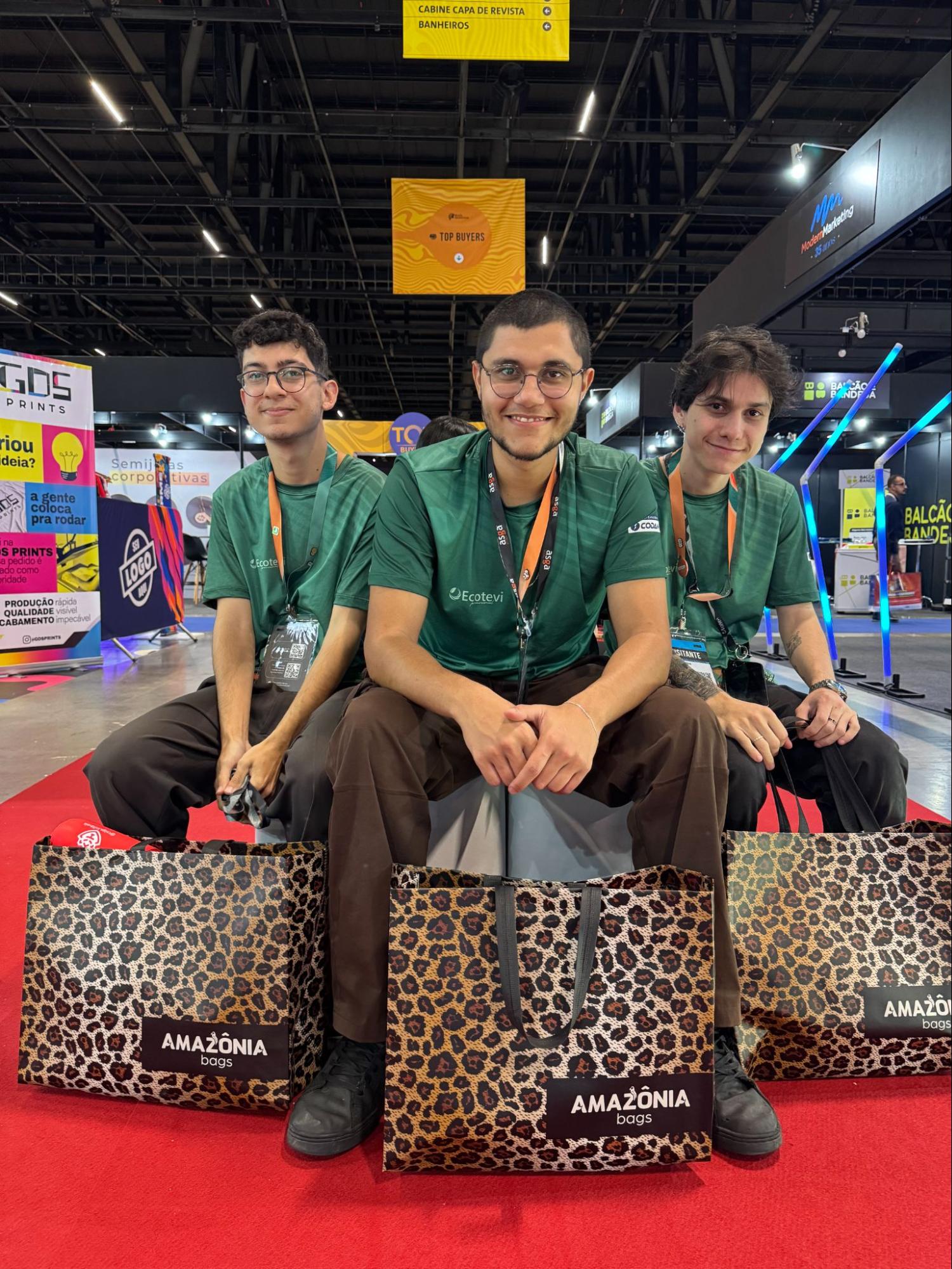 Três homens em um evento com sacolas personalizadas grandes e resistentes